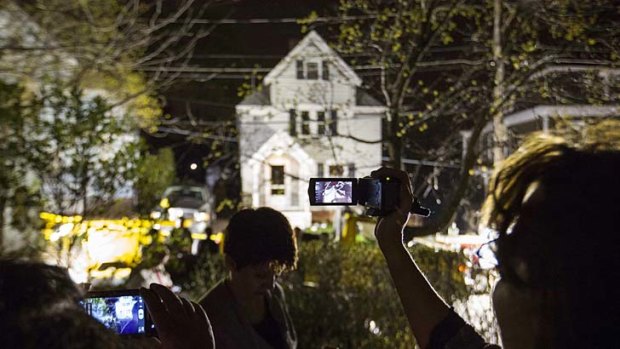 Watching the action: neighbours use cameras to record images of the boat where Dzhokhar Tsarnaev was hiding.