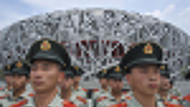 Paramilitary policemen in front of the main Olympic stadium are part of a clampdown as Beijing gets ready to welcome the world.
