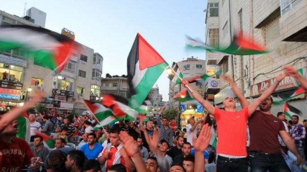 Landmark victory: Palestinian football fans celebrate in the West Bank city of Ramallah.