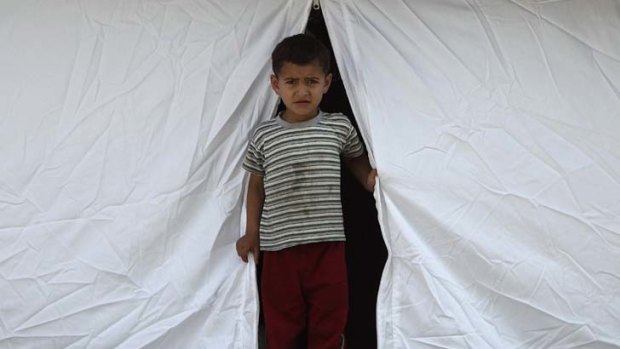 A child stands outside a medical tent in a Syrian refugee camp in the Turkish border town of Yayladagi.