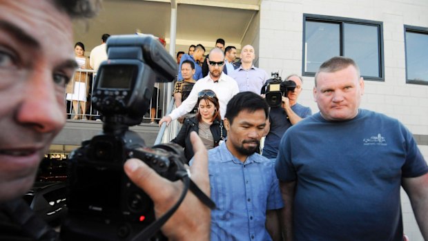 Manny Pacquiao with promoter Deano Lonergan (right) leave a church in Carina at the weekend.