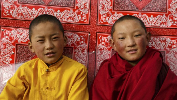 Two young nuns relaxing outside the main temple in the afternoon. Their life of devotion starts when girls are as young as six.