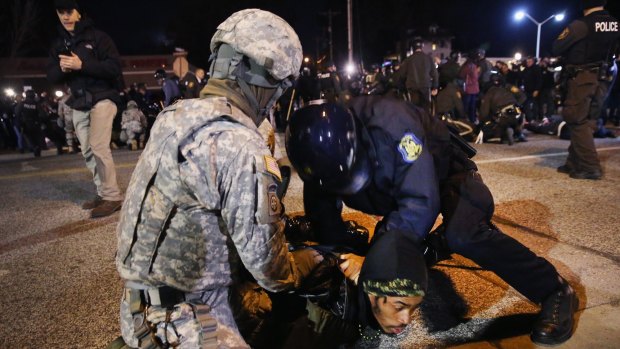 Police and national guard arrest a demonstrator outside the police station November 28, 2014 in Ferguson, Missouri. 