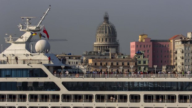 Passengers stand on Carnival's Adonia cruise ship as they arrive.