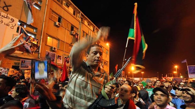 Jubilation ... people celebrate in Benghazi at the news that Muammar Gaddafi's youngest son, Saif al-Arab, had been killed in a NATO air strike.