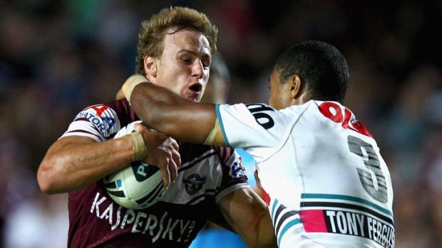 Daly Cherry-Evans of the Sea Eagles is tackled by Michael Jennings of the Panthers.