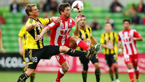 Reckless: Wellington Phoenix defender Ben Sigmund (left) earned his second yellow card after this tackle on Heart's Harry Kewell during the 2-2 draw at AAMI Park.