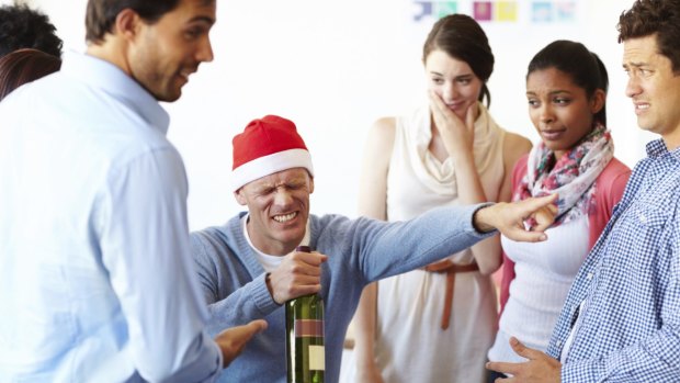 A male employee having too much fun at the office party while his colleagues look on  Christmas party, office christmas party, generic, istock
