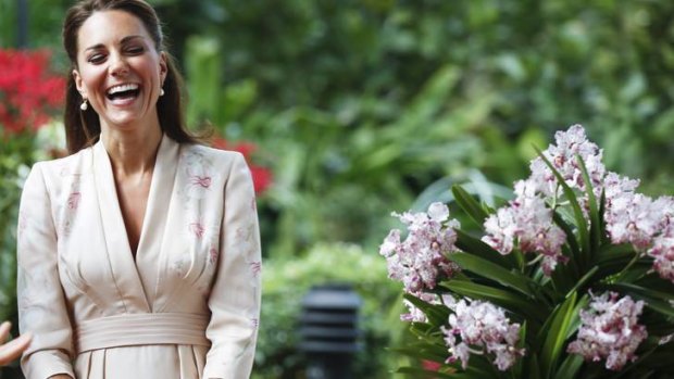Reason to be cheery? Catherine, the Duchess of Cambridge, smiles during a ceremony in Singapore yesterday. Onlookers speculate that her dresses are less fitted than usual - a possible hint of pregrancy.