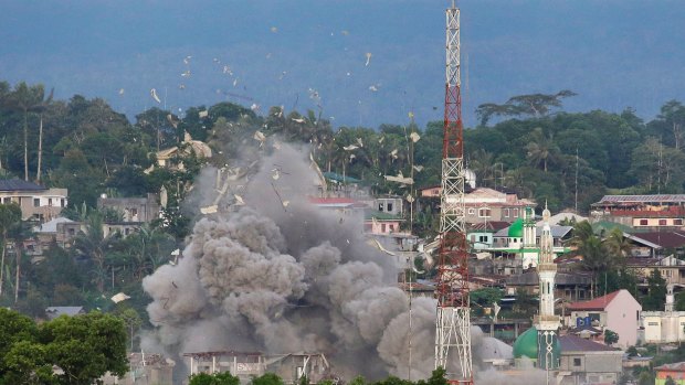 Debris flies as the Philippine Air Force bomb suspected locations of Muslim militants in Marawi Cty. 
