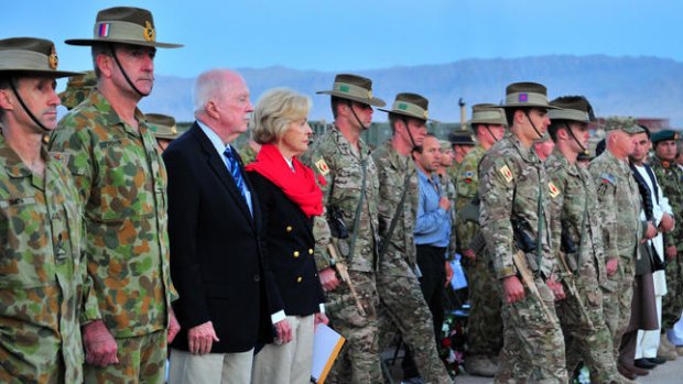 Governor-General Quentin Bryce and her husband, Michael, stand with troops at the dawn service to commemorate Anzac Day on the Australian base in Afghanistan.