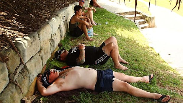 Cooling off ... tourists seek comfort in a patch of shade at Sydney's Bondi Beach.