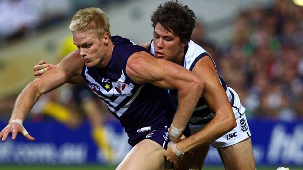 Adam McPhee of the Dockers and Andrew Mackie of the Cats contest the ball.