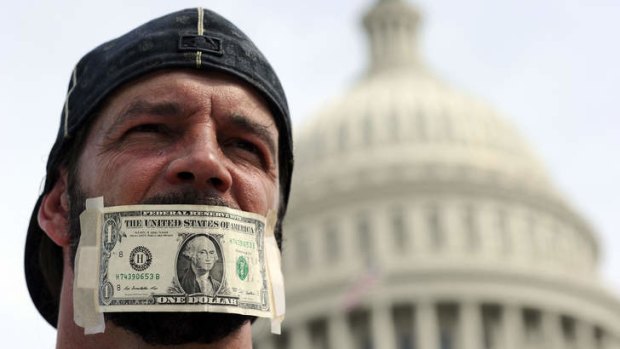 A protester has his mouth covered with a dollar bill during a demonstration in Washington DC, urging congress to end the federal government shutdown.