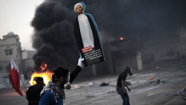 A Bahraini protester holds up a placard showing Shiite opposition leader Sheikh Ali Salman during clashes with police on January 30.