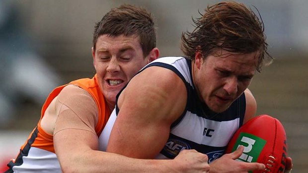 Mitch Duncan of the Cats is challenged by Sam Darley of the Giants.