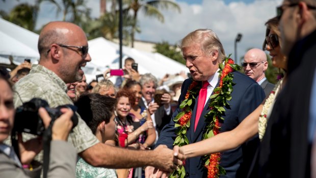 President Donald Trump and first lady Melania Trump, right, greets guests at at Pearl Harbour on Friday.