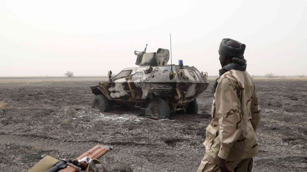A file photo of a Chadian soldier walking past an armored vehicle that the Chadian military said belonged to Boko Haram. 