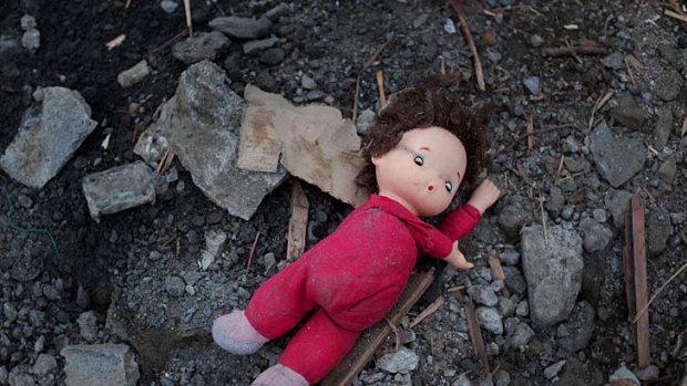 Left behind... a child's doll in the rubble of the town.
