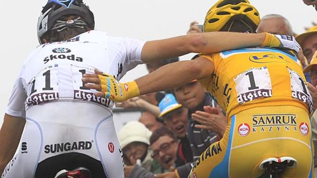 Andy Schleck of Luxembourg embraces Alberto Contador of Spain as they  cross the finish line.