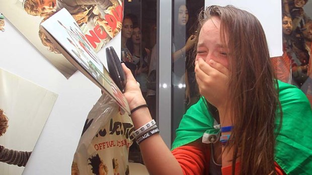 Overcome with emotion ... a fan cries after buying merchandise at the One Direction promotional store.