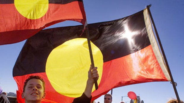 Unity ... a boy and his mother carry the Aboriginal flag as they cross the Sydney Harbour Bridge.