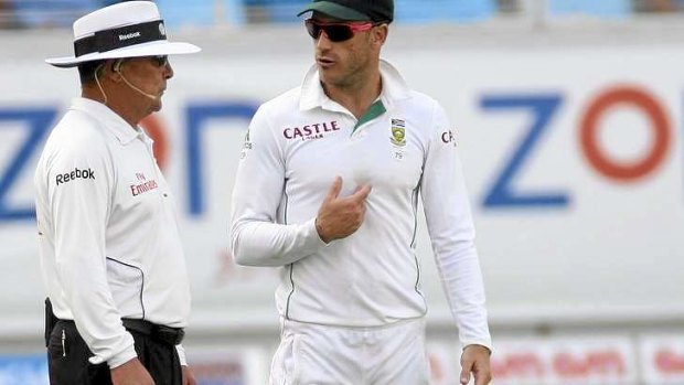 Umpire Ian Gould talks to South Africa's Faf du Plessis.