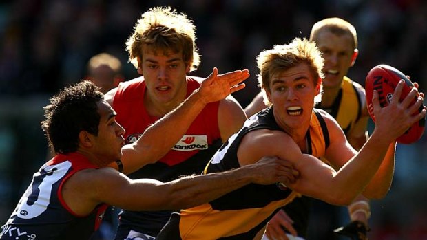 David Astbury of the Tigers is tackled by Jamie Bennell of the Demons during their tight round 19 AFL match last year.