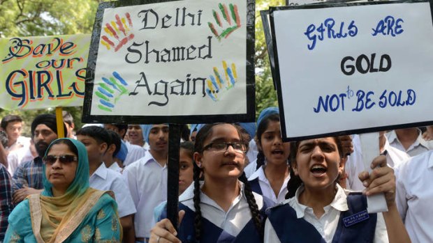 National uproar: Indian schoolchildren and teachers shout slogans as they carry placards during a demonstration against the rape of a five-year old girl.