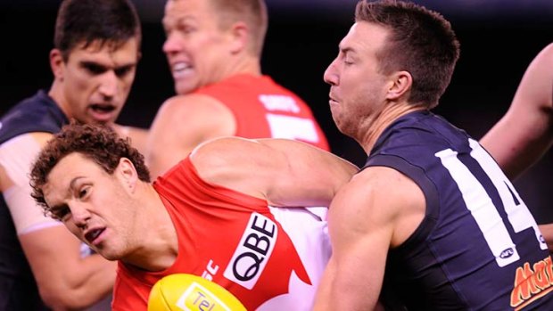 Sydney's Shane Mumford is tackled by Carlton's Brock McLean.