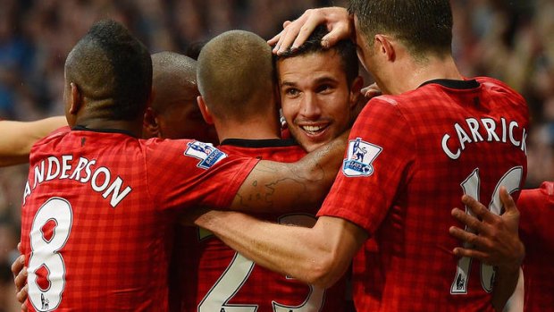 Dream start ...   Robin van Persie is congratulated after opening his account for United.