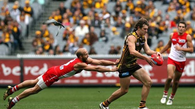 Bump-free zone ... Jarrad McVeigh of the Swans tries to tackle Grant Birchall of the Hawks at the MCG yesterday.  Hawks players have been instructed not to bump because of the risk of collision.