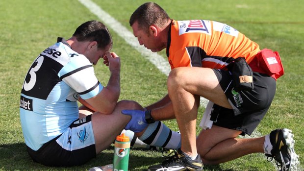Paul Gallen of the Sharks is attended to by a trainer after getting injured during the round eight NRL match between the Newcastle Knights and the Cronulla Sharks at Hunter Stadium on May 5, 2013 in Newcastle, Australia.