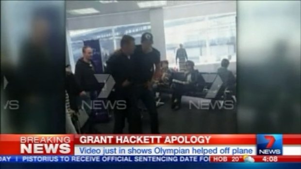 Grant Hackett is helped by a fellow passenger after the flight from Adelaide to Melbourne.