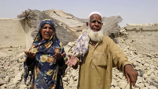 Tragedy: An elderly Pakistani couple gesture in front of their destroyed home in the devastated district of Awaran.