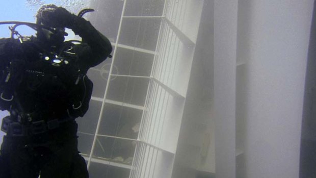 A diver swims next to the cruise ship.