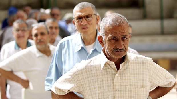 Voters wait in line to cast their votes at a polling station in the coastal city of Alexandria.