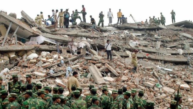 Bangladeshi soldiers guard the site of a collapsed garments factory near Dhaka in 2005. 