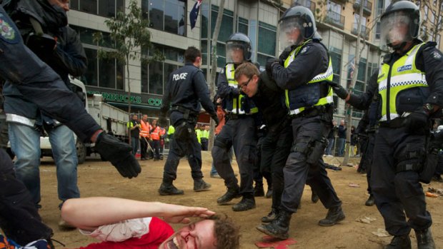 A bleeding protester shouts as riot police move in to remove Occupy Melbourne protesters from City Square.