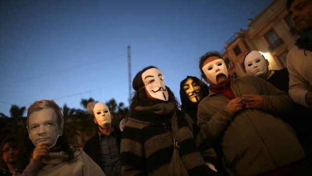 WikiLeaks supporters wear masks of the "Anonymous" internet activists and an Assange mask, left, at a rally in Malaga, Spain.