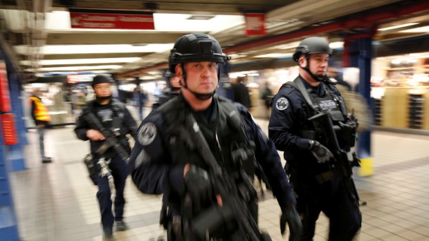Police officers patrol in the passageway connecting New York City's Port Authority bus terminal and the Times Square subway station.
