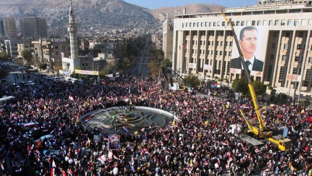 Pro-Syrian regime protesters gather during a protest against sanctions, in Damascus, Syria, on Friday December 2, 2011.