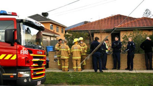 Deadly blaze ... Firefighters and police officers outside a Hampton East home where a woman was killed.