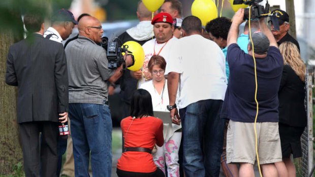 A life reclaimed: Michelle Knight (centre, wearing glasses) at Ariel Castro's home in August 2013 on the day it was torn down.