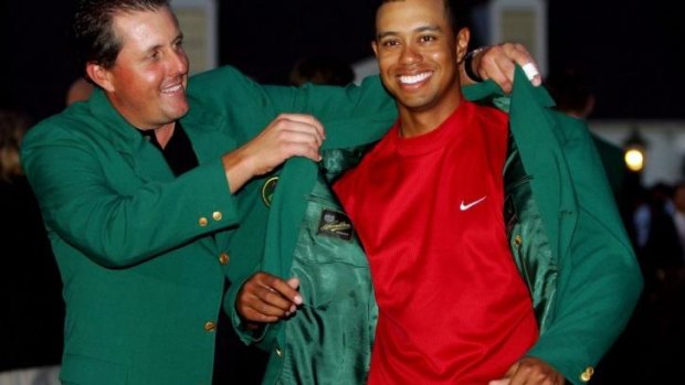 Phil Mickelson presents Tiger Wood with the green jacket in 2005.