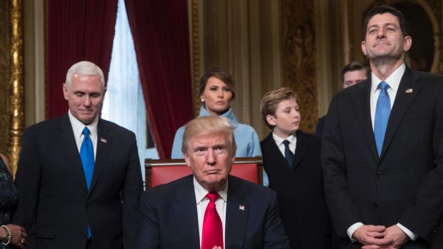 Barron Trump stands with his mother Melania as President Donald Trump prepares to formally sign his cabinet nominations into law.