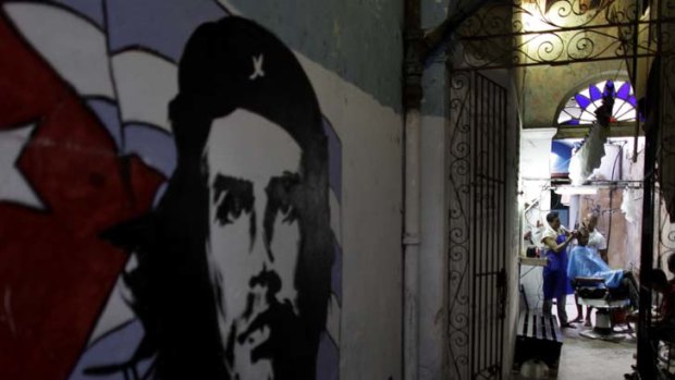 Gently does it ... a mural of Che Guevara on a wall leading to a barbershop in Old Havana. Cuba is undertaking a cautious overhaul of its Soviet-style economy.