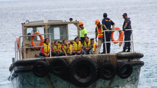 Vietnamese asylum seekers are brought ashore at  Christmas Island.