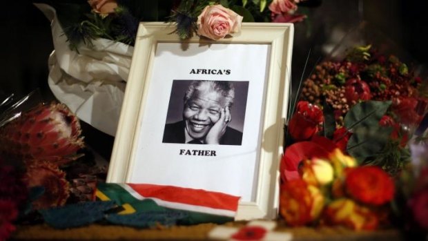 Flowers and tributes are left on the Nelson Mandela statue on Parliament Square in London.