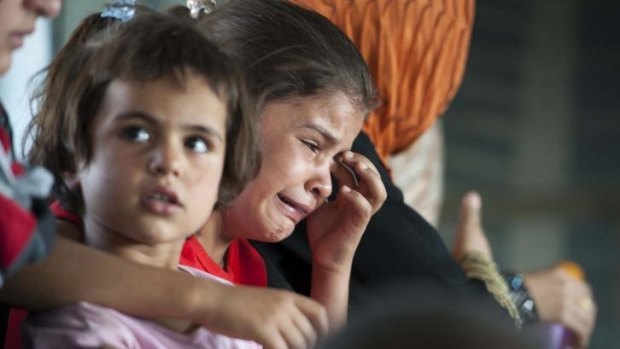 A child cries in a military helicopter after being evacuated by Iraqi forces from Amerli.